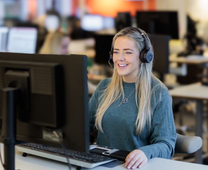 Kvinne sitter på kundesenteret og svarer telefonen